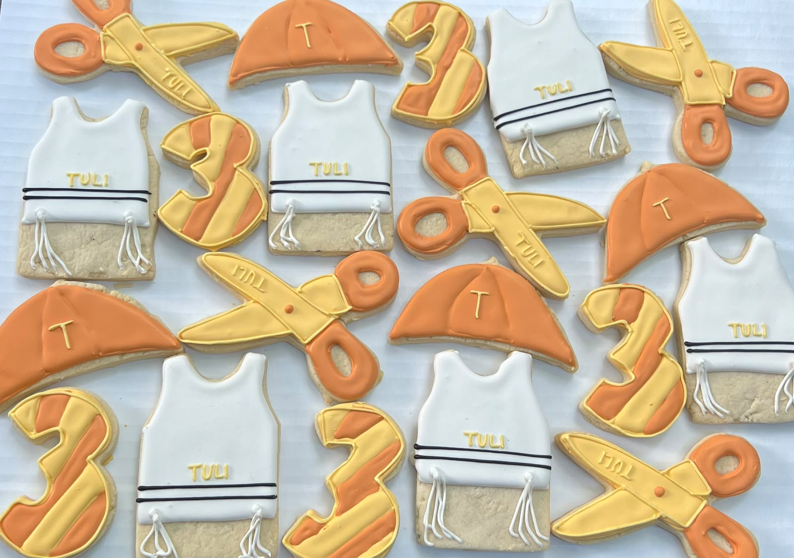 Custom-iced cookies shaped like numbers and party icons